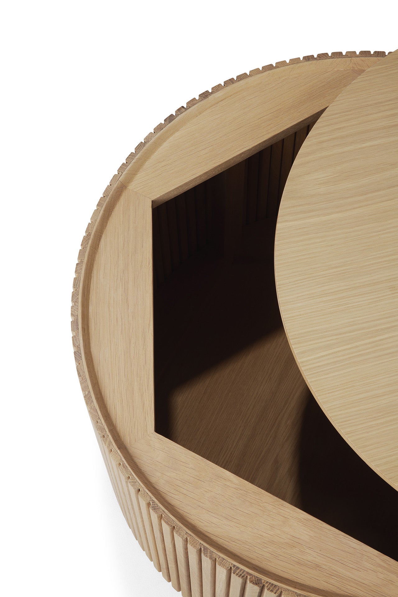 The Ethnicraft Roller Max Coffee Table – Oak features a round solid oak design with a smooth top, ribbed textured sides, and a partially open circular lid that reveals hidden inner storage.