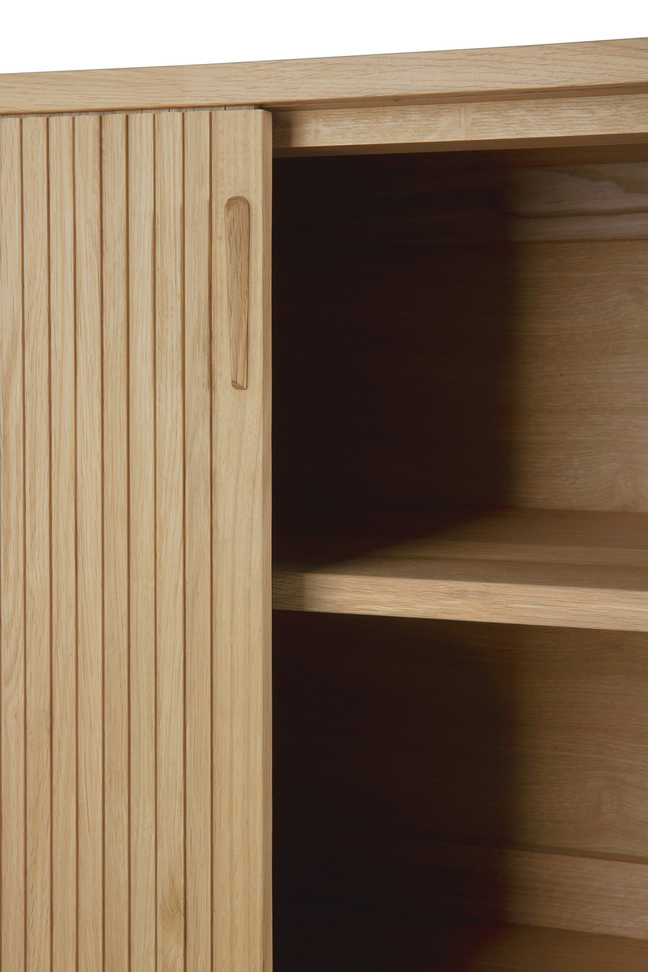 Close-up of the Ethnicraft Roller Max Sideboard in light wood, featuring vertical grooves and a partially open sliding door that reveals two interior shelves.