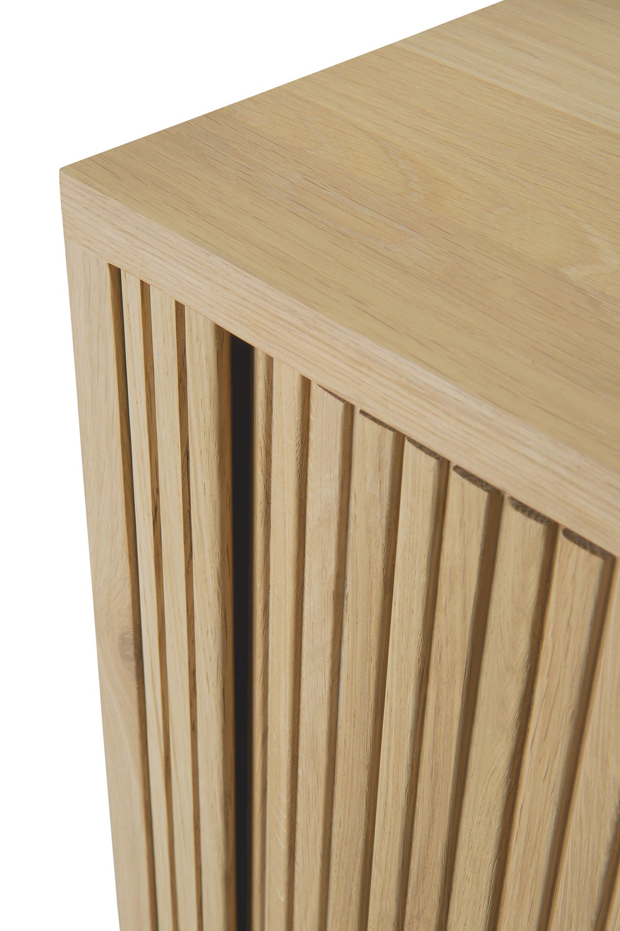 Close-up of an Ethnicraft Roller Max Sideboard corner, showing vertical slatted detailing on the front and emphasizing the natural grain and texture of solid oak.