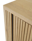 Close-up of an Ethnicraft Roller Max Sideboard corner, showing vertical slatted detailing on the front and emphasizing the natural grain and texture of solid oak.