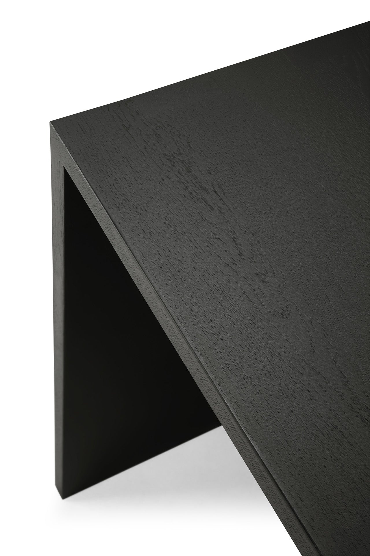 Close-up of a modern Ethnicraft U Desk in black oak, featuring clean, sharp edges and minimalist design. The image highlights the rich wood grain texture on both the desk surface and leg.