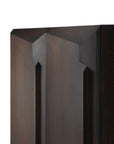 Close-up of the Ethnicraft Stairs cupboard - Oak Brown, showcasing its solid oak panel with angular, geometric carvings and vertical grooves. The rich wood grain and modern design stand out against a plain white background.