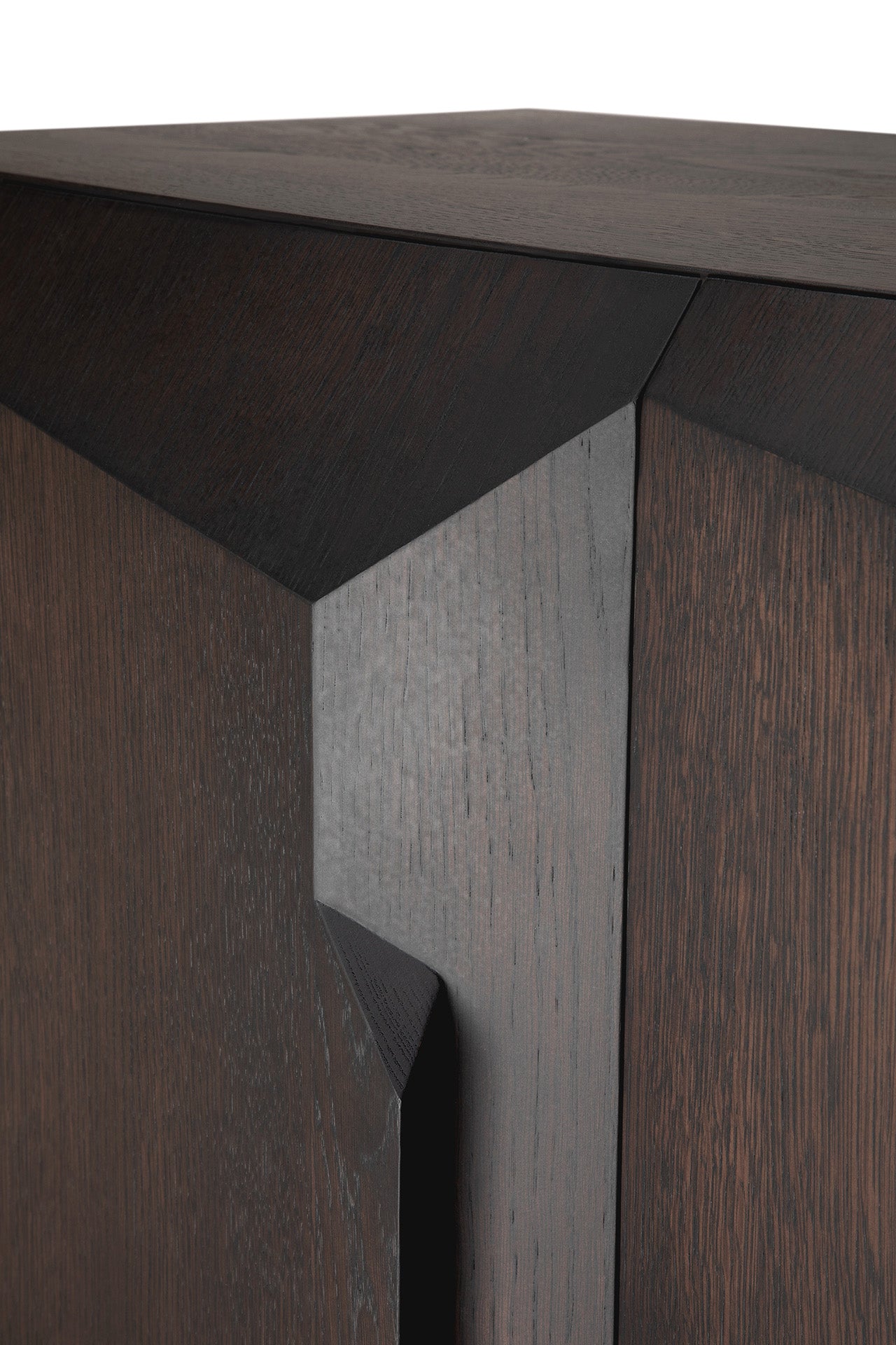 Close-up of the Ethnicraft Stairs cupboard in Oak Brown, showcasing its geometric, angular design with sharp edges, visible wood grain, and seamlessly integrated push-to-open doors that reflect fine craftsmanship.