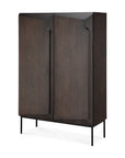 The Ethnicraft Stairs cupboard in Oak Brown features a modern design with solid oak, push-to-open doors, and minimalist black metal legs, displayed against a white background.