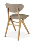 The Ethnicraft Eye Dining Chair features solid European oak legs and frame, a curved backrest, and a padded seat in warm grey fabric. Shown from the back-side angle on a white background.
