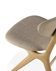 A close-up of the Ethnicraft Eye Dining Chair - Oak with Warm Grey Fabric highlights its solid oak frame, warm grey upholstered seat, and gracefully curved backrest, all set against a white background.