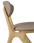 The Ethnicraft Eye Dining Chair features a solid European oak frame, curved backrest, and a warm grey fabric seat cushion. Its smooth lines and minimalist design are inspired by modern aesthetics.