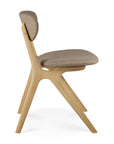 The Eye Dining Chair by Ethnicraft features a solid oak frame, angled legs, and warm grey fabric upholstery on the seat and backrest. Shown in side view against a white background.