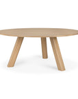 Round solid oak Unda dining table by Ethnicraft, featuring three thick, angled legs.
