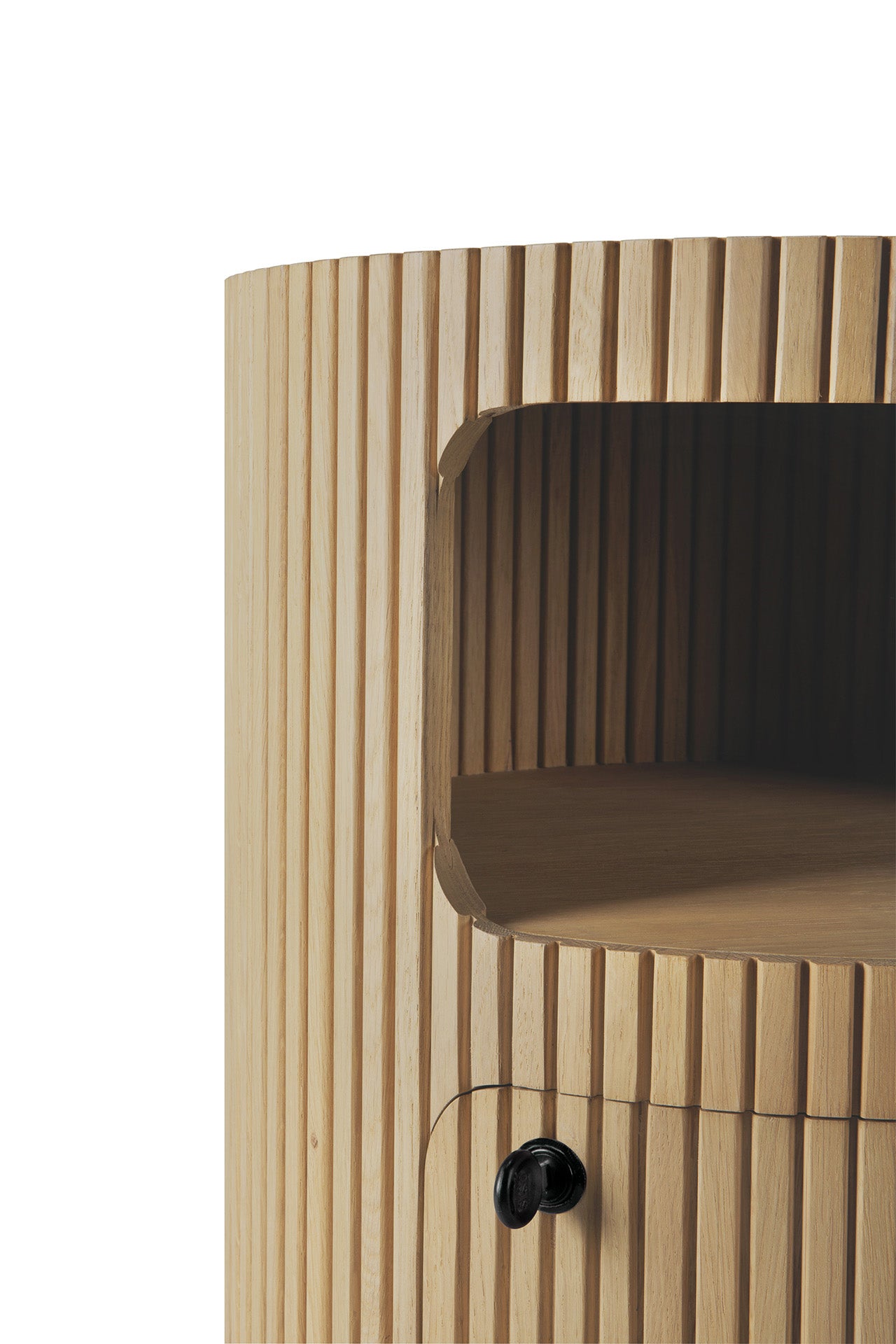 Close-up of the Ethnicraft Boomerang Drawer Unit - Oak, featuring vertical grooves, an open shelf, and a small round black knob on the lower compartment. The solid oak has a light, natural finish.