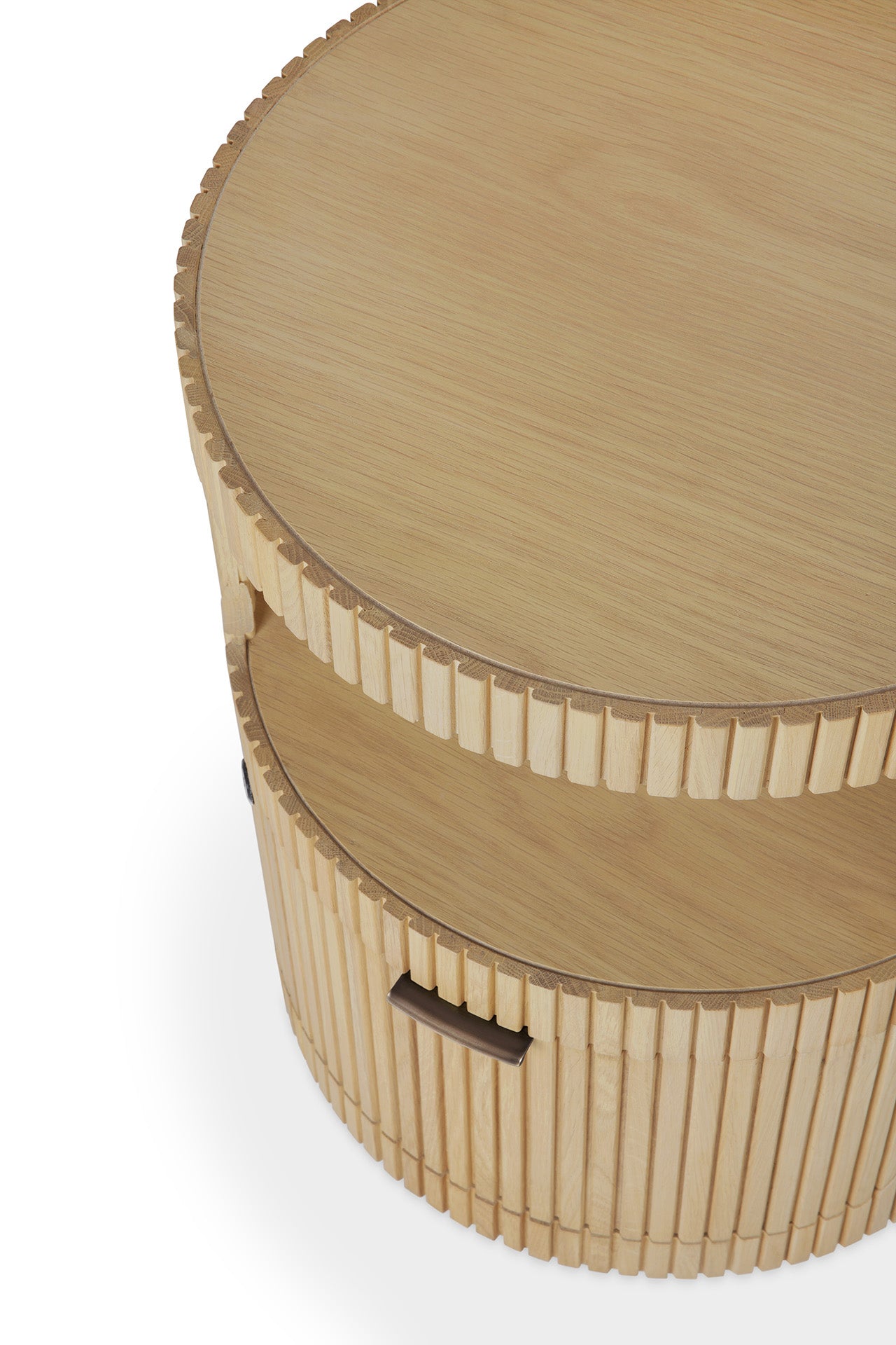 The Ethnicraft Boomerang Drawer Unit - Oak is a round wooden coffee table with solid oak, fluted sides, an open shelf, a smooth top, and a side handle that hints at its concealed storage compartment.