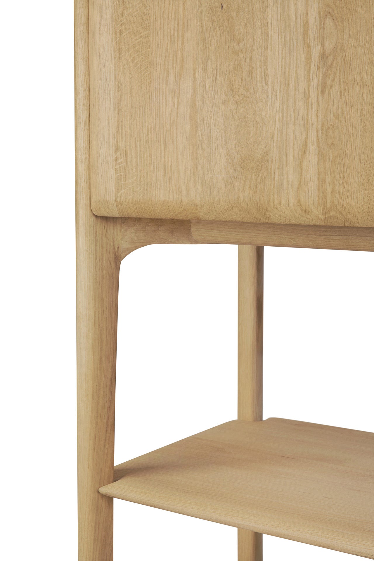 Close-up of the Ethnicraft PI Cupboard - Oak, featuring smooth, rounded legs, a lower shelf, and visible wood grain that highlights its minimalist design and handcrafted storage furniture quality.