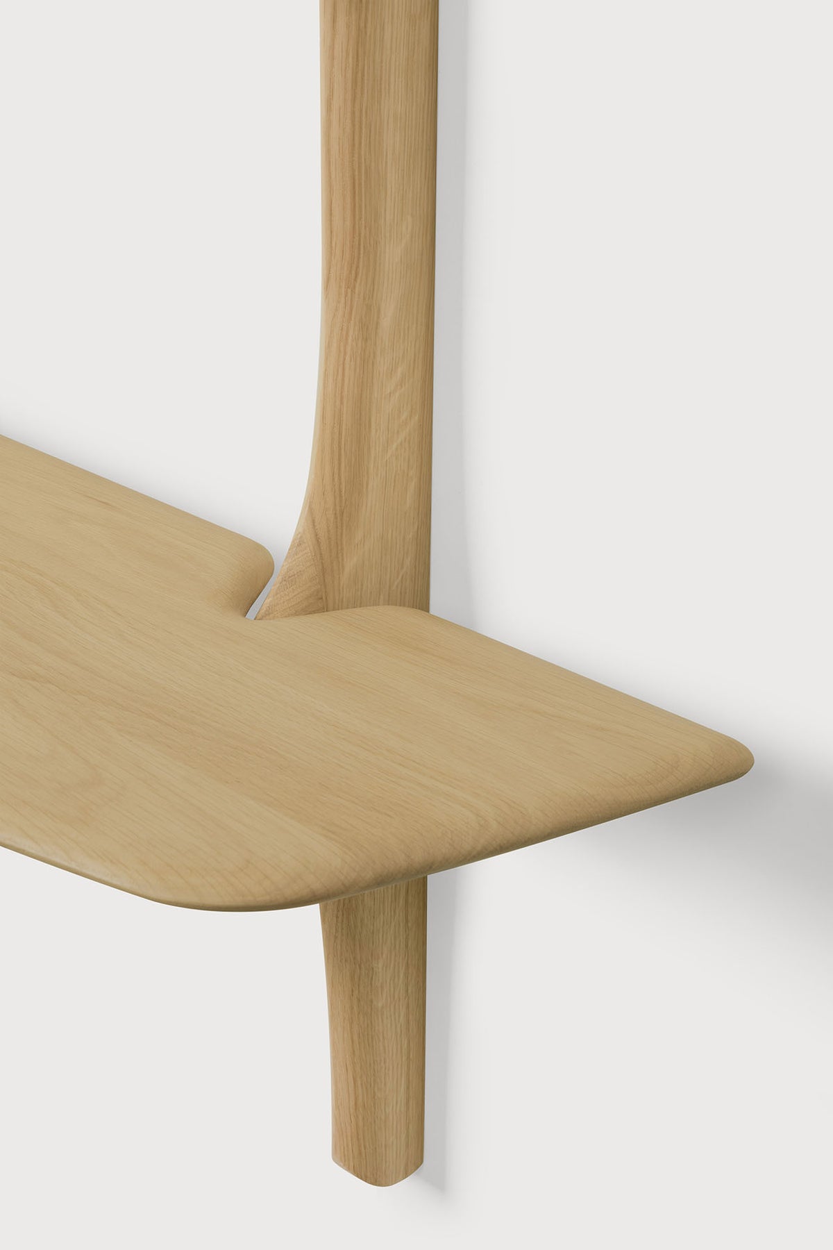 An Ethnicraft PI Wall Mounted Desk featuring a solid oak, rounded tabletop attached to a vertical support.