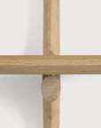 Close-up of a light solid oak Ethnicraft PI Wall Mounted Desk featuring an intersecting support structure joined by a small wooden oval-shaped fastener.