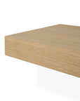 A close-up of the corner of the Ethnicraft Wall Shelf - Oak, crafted from European oak with a light natural finish, set against a white background.