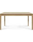 The Ethnicraft Bok Dining Table in varnished oak features a rectangular shape, four straight legs, and a smooth light wood finish, shown from the front against a white background.