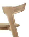 Close-up side view of the Ethnicraft Bok counter stool, featuring a smooth, minimalist design in solid oak with an angled backrest and clean lines, shown against a white background.