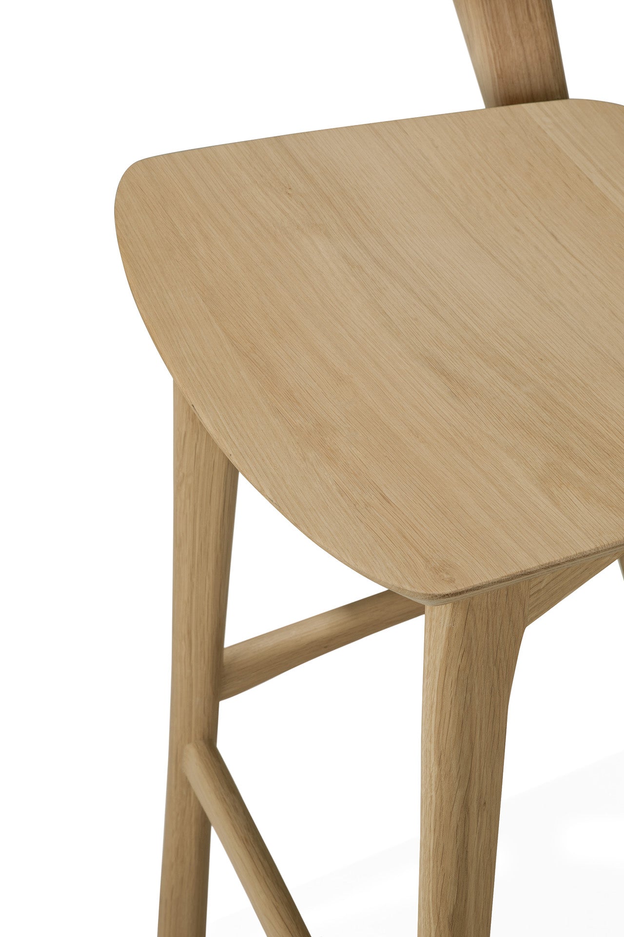 Close-up of an Ethnicraft Bok counter stool made from solid oak, showcasing the smooth, light wood finish on the seat, legs, and back support against a white background.