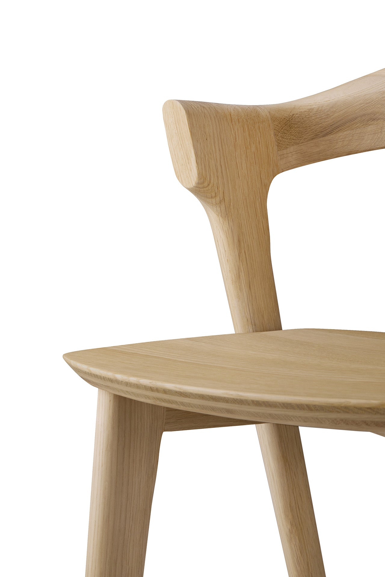 Close-up of an Ethnicraft Bok counter stool, crafted from solid oak, highlighting its smooth natural finish, angled backrest, and curved seat against a white background.