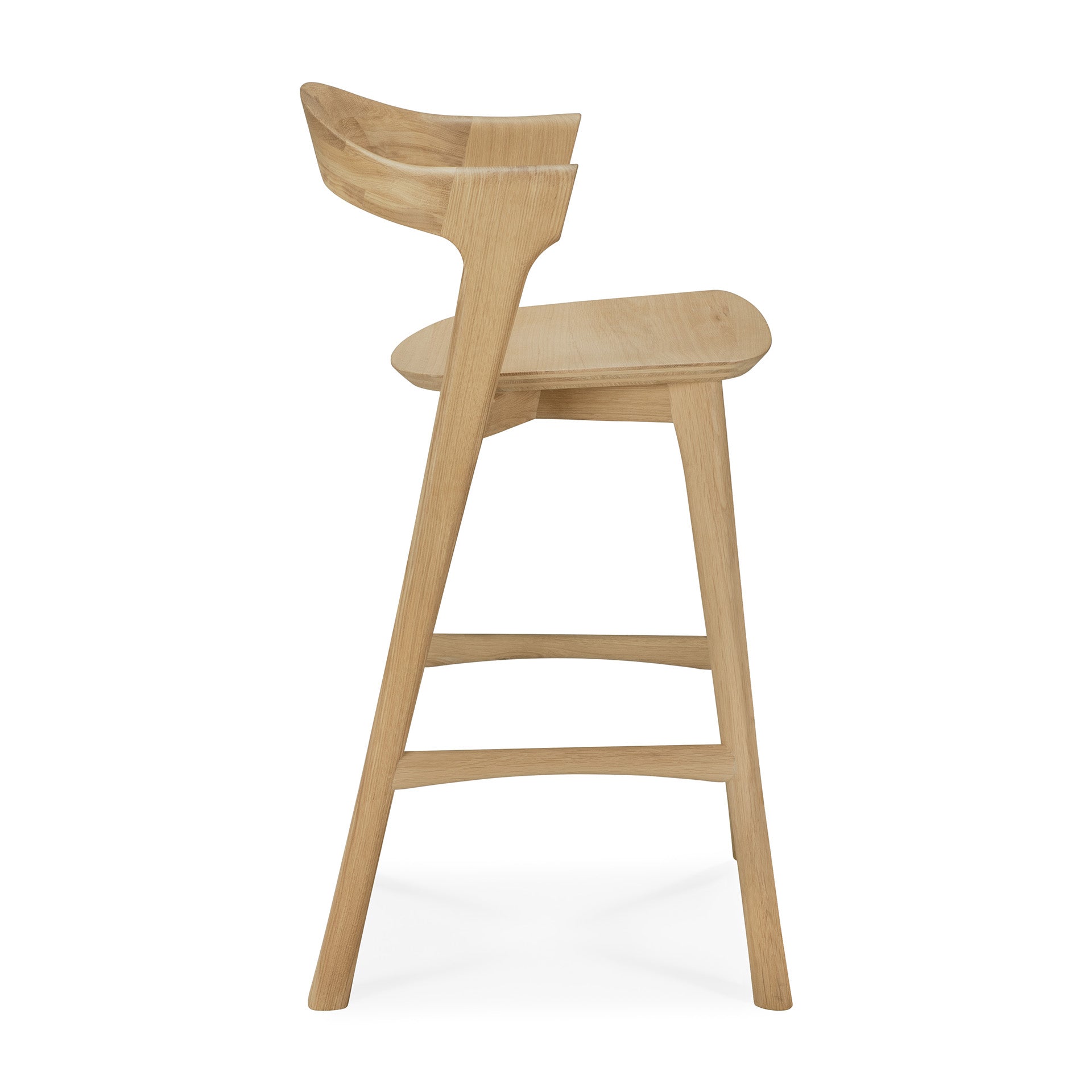 Side view of the Ethnicraft Bok counter stool, crafted from solid oak with a natural light finish. Features a curved backrest, flat seat, and angled legs with support bars, inspired by the Bok dining chair design.