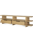 The Ethnicraft Kabuki TV cupboard in oak is a modern wooden TV stand, featuring two central drawers and multiple open shelves on each side, elegantly finished in light oak with varnished teak accents, set against a plain white background.
