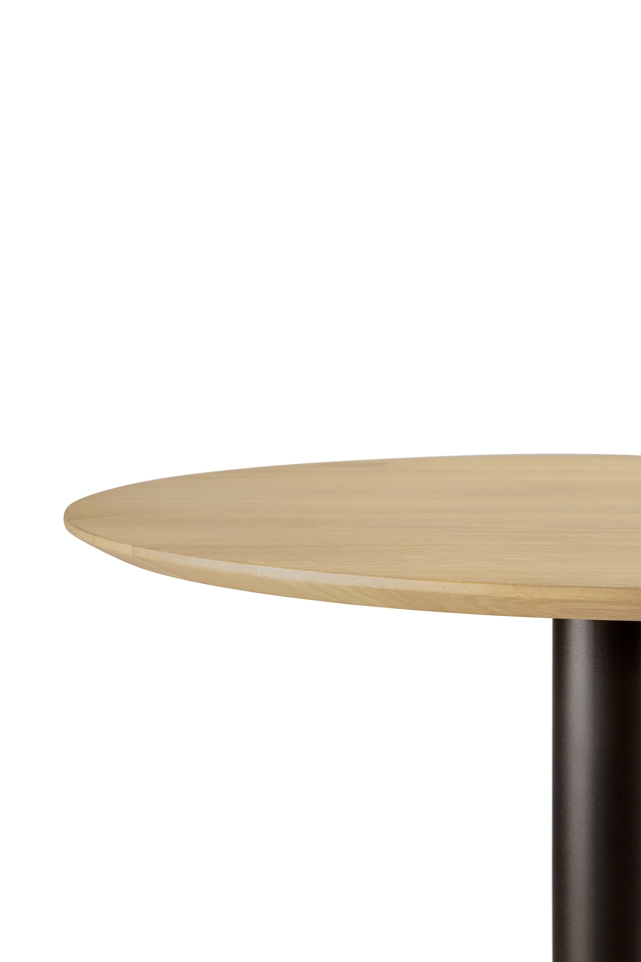 The Ethnicraft Blend Dining Table - Oak features a round solid oak top with a light finish, a single black cylindrical leg, and interchangeable tops, showcased against a plain white background.