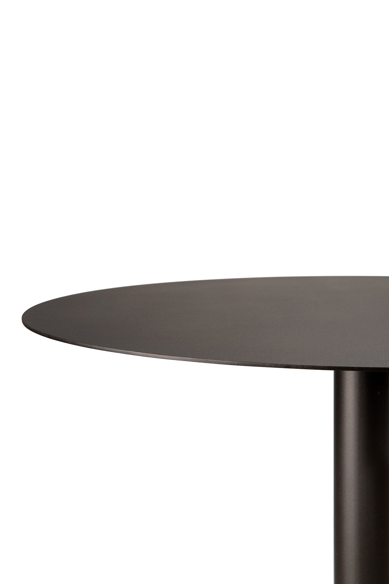 A close-up of the Ethnicraft Blend Dining Table - Dark Bronze Metal shows a round, dark bronze top with a single cylindrical leg. Against a white background, only part of the tabletop and leg are visible.