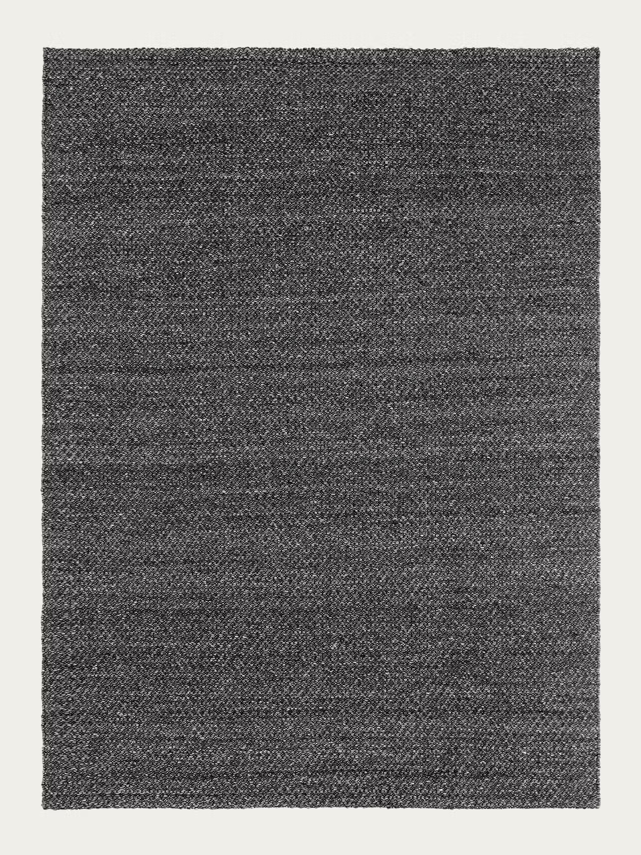 A rectangular Sherpa Rug in charcoal, handwoven from wool by Armadillo&Co, featuring a subtle textured pattern on a light background.