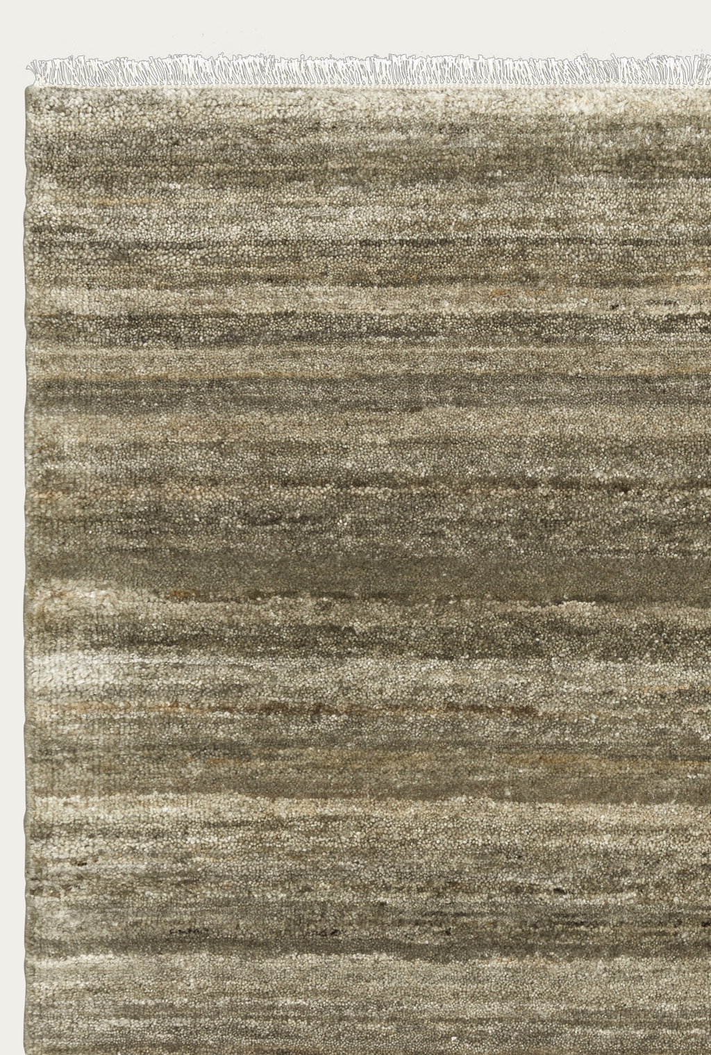 A section of the Odessa Rug - Caraway by Armadillo&amp;Co shows natural wool striations, a textured horizontal stripe pattern in beige, tan, and gray, and fringed edges along the top.