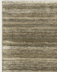 A section of the Odessa Rug - Caraway by Armadillo&Co shows natural wool striations, a textured horizontal stripe pattern in beige, tan, and gray, and fringed edges along the top.