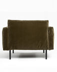 The Attendant Lounge Chair by Wooden Stories is shown from the back in green velvet fabric, with a boxy shape, wide arms, and slim black metal legs, set against a plain white background.