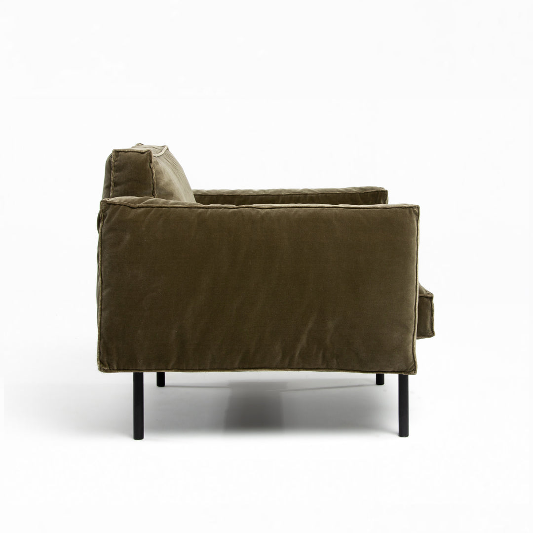 Side view of the Wooden Stories Attendant Lounge Chair in olive green fabric with black metal legs, displayed against a plain white background.