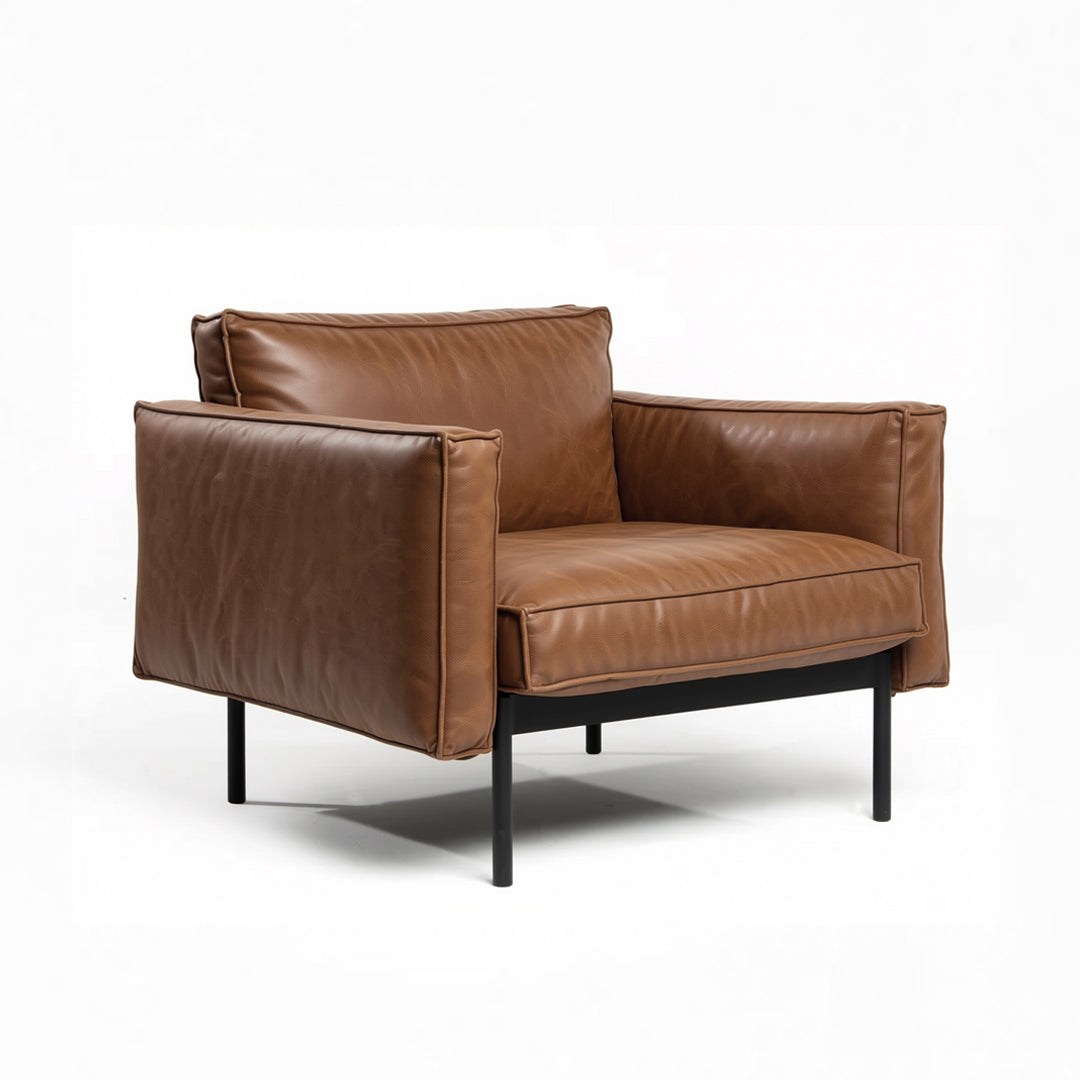 The Attendant Lounge Chair by Wooden Stories features modern brown leather, wide cushions, black metal legs, and a minimalist design—ideal for fans of Danish collections.