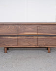 The SOBU Jupiter Sideboard - Walnut 3-door features a rich wood grain and short round legs, set on a grey carpet against a plain white background.