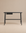 A minimalist black oak Author Desk from Wooden Stories, part of the Danish collection, featuring a small central drawer and set against a plain beige background.