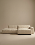 The Wooden Stories Baker Modular Sofa | Fabric • M4, featuring clean lines and low seating in minimalist beige, is styled against matching beige walls and floors for a simple, modern look.