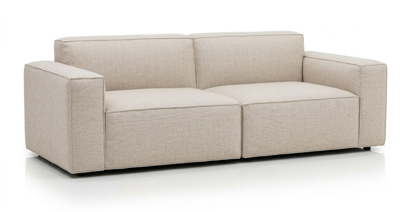 The Baker Sofa | Fabric by Wooden Stories features a modern design in light beige with square armrests and clean lines, set against a white background.