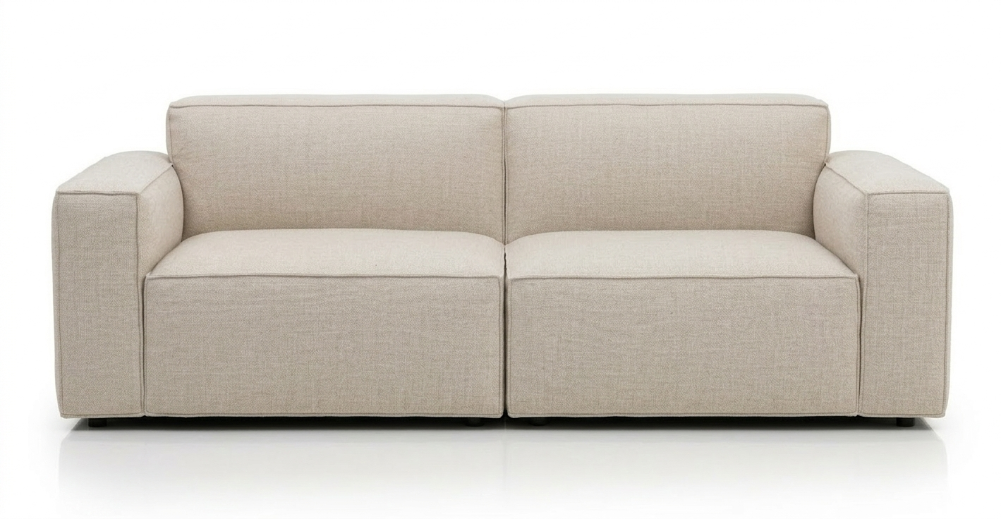 The Baker Sofa | Fabric by Wooden Stories is a modern, light beige Danish sofa with clean lines, wide armrests, and a low backrest, offering supportive comfort against a plain white background.