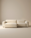 The Baker Modular Sofa | Fabric • M3 by Wooden Stories features a modern, minimalist beige design with wide armrests and a low backrest, showcased against a plain, neutral-colored background.