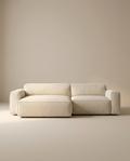 The Baker Modular Sofa | Fabric • M3 by Wooden Stories features a modern, minimalist beige design with wide armrests and a low backrest, showcased against a plain, neutral-colored background.