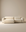 The Baker Modular Sofa | Fabric • M3 by Wooden Stories features a modern, minimalist beige design with wide armrests and a low backrest, showcased against a plain, neutral-colored background.