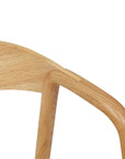 Close-up of Wooden Stories Inlay Dining Chair | Light Oak, capturing the curved backrest and armrest details, and showcasing the natural wood grain and smooth finish.
