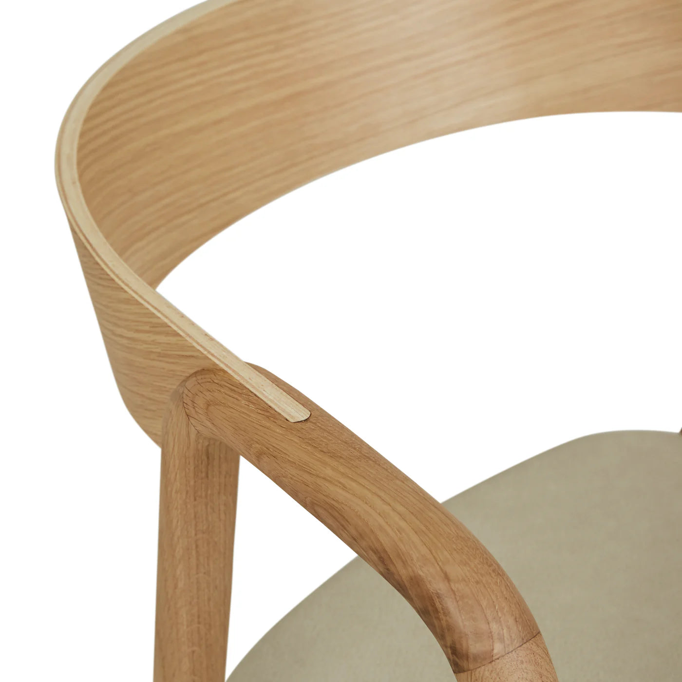 Close-up of the Wooden Stories Inlay Dining Chair in light oak and leather, featuring a smooth, curved plywood backrest, armrests with natural wood grain, and a light beige leather seat against a white background.