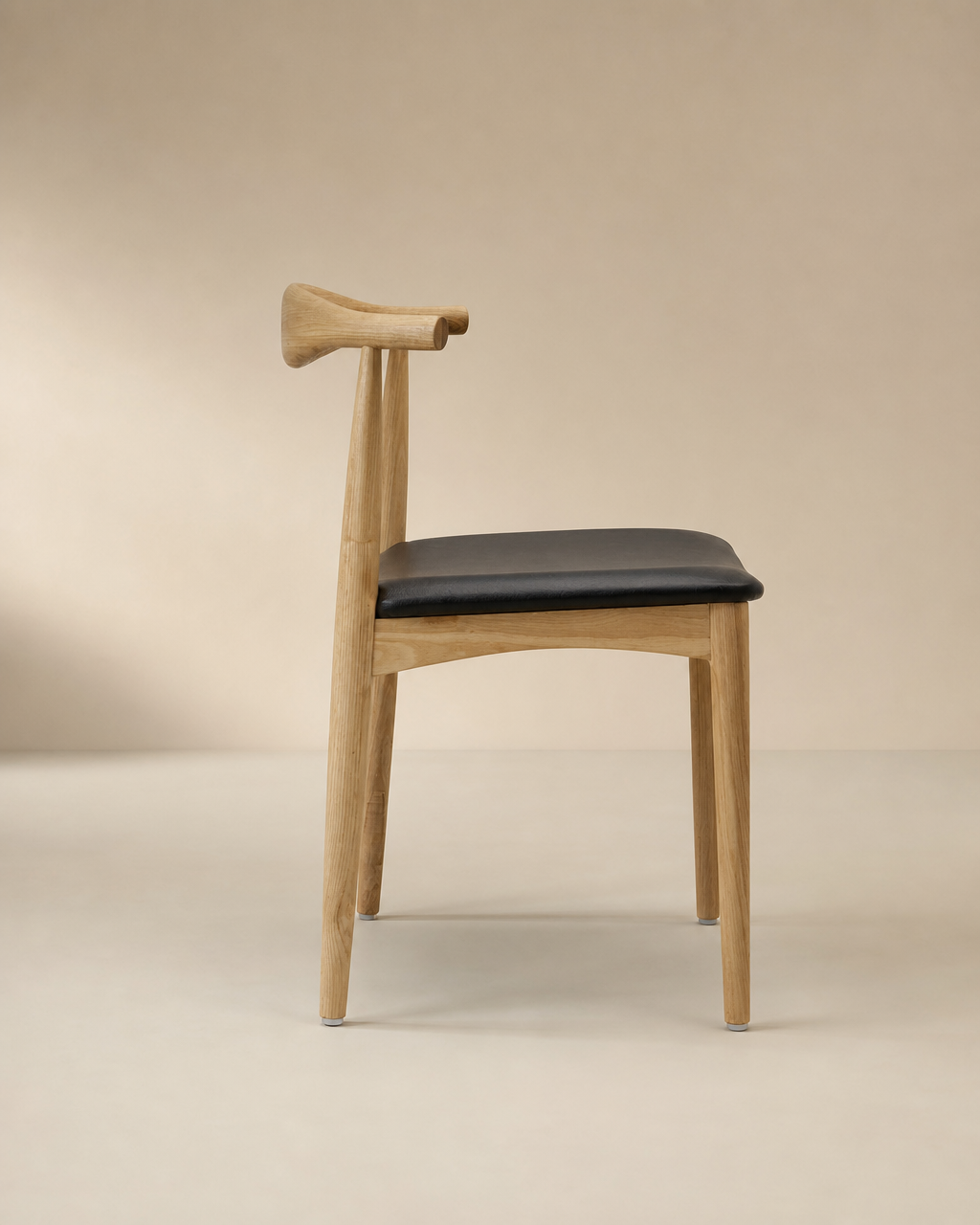 The SOBU Copenhagen Dining Chair in White Ash features a minimalist solid wood frame, black cushioned seat, and a curved backrest, shown in profile against a neutral beige background.