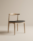 The Copenhagen Dining Chair by SOBU features a minimalist mid-century design with a curved backrest, black leather seat, and solid white ash wood, shown against a plain beige background.
