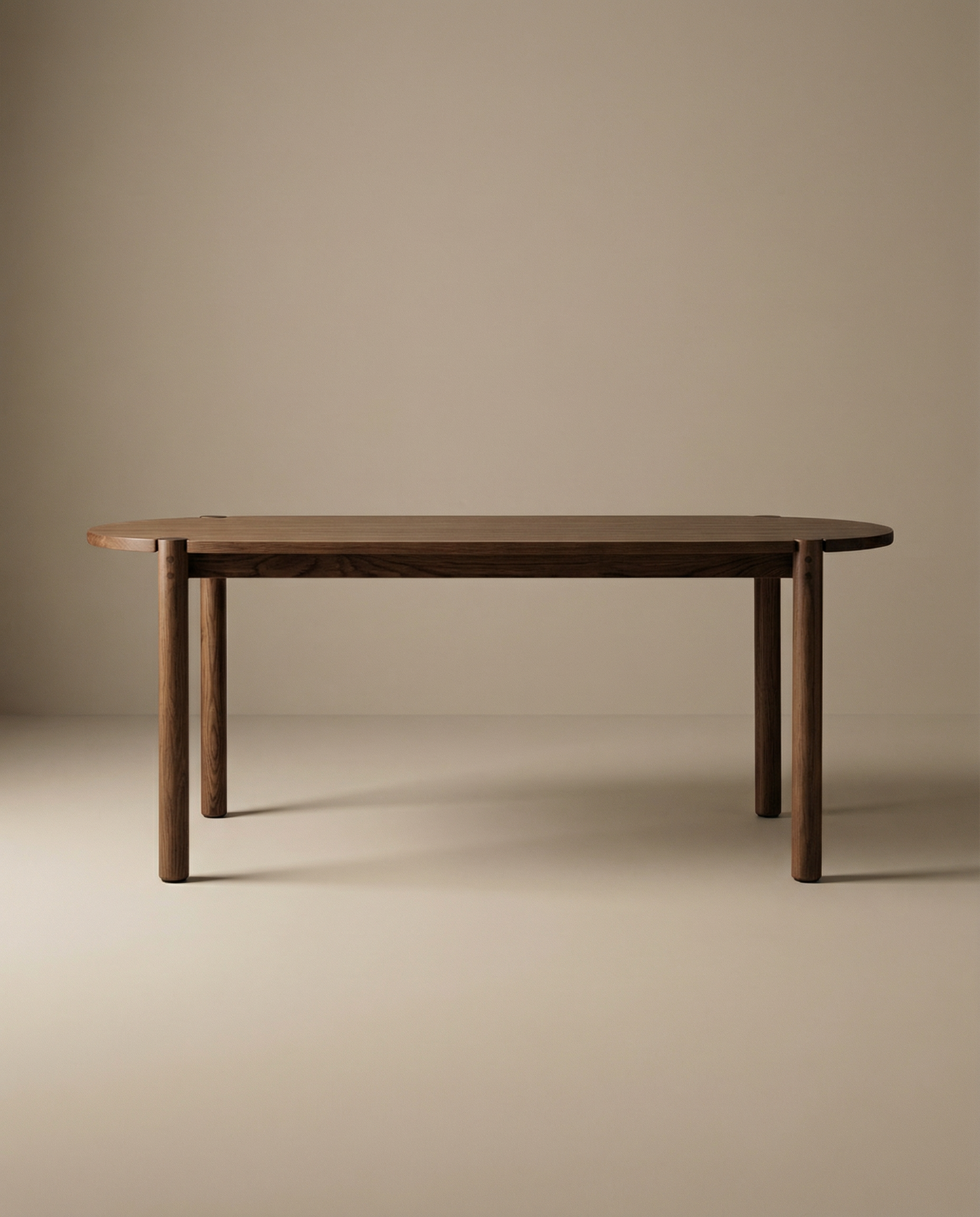 The Wooden Stories Cove Dining Table | Espresso Oak is a simple, modern piece made from solid American oak with rounded edges and cylindrical legs, shown against a plain beige background.