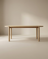 The Wooden Stories Cove Dining Table | Light Oak features solid American oak with rounded edges and four cylindrical legs, shown against a neutral beige background in a softly lit room.