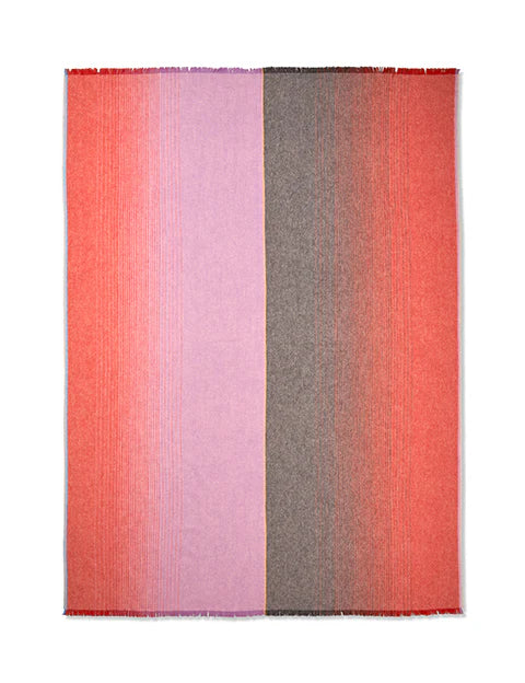 The Carte Postale Throw - Red Pink by Elvang Denmark is a rectangular woven alpaca wool blanket with vertical color blocks: the left side fades from red to light pink, the right from gray to red, featuring subtle horizontal lines and fringe edges.