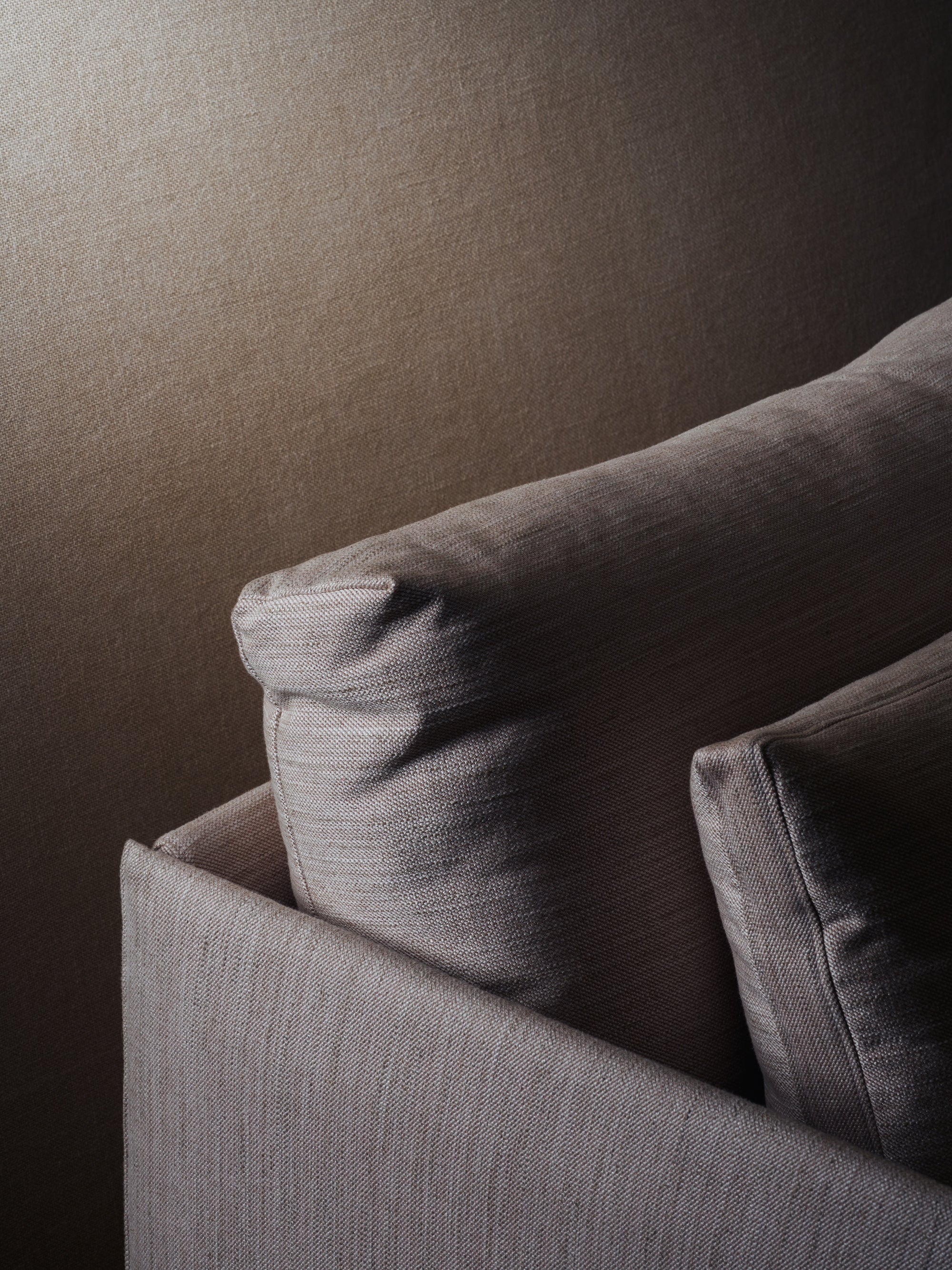 Close-up of the Cherry Sofa 79" | Fabric by Wooden Stories, featuring textured light brown cushions against a matching wall—creating a soft, minimalistic look ideal for modern spaces with subtle Danish-inspired lines.