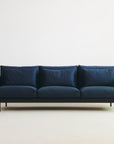 The Cherry Sofa 95" | Fabric by Wooden Stories features Danish-inspired minimalist design, three large cushions, slim black legs, and a clean look—an ideal centerpiece for modern living spaces.